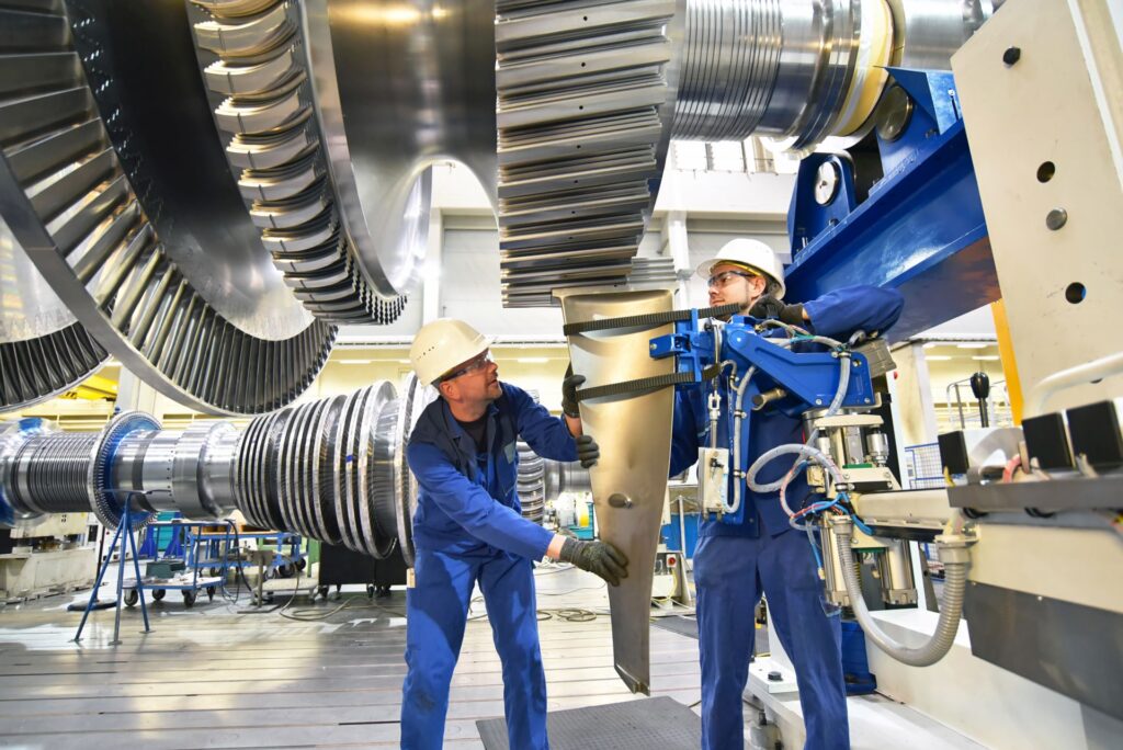 Arbeiter in einer Industriefabrik arbeiten an einer Turbine
