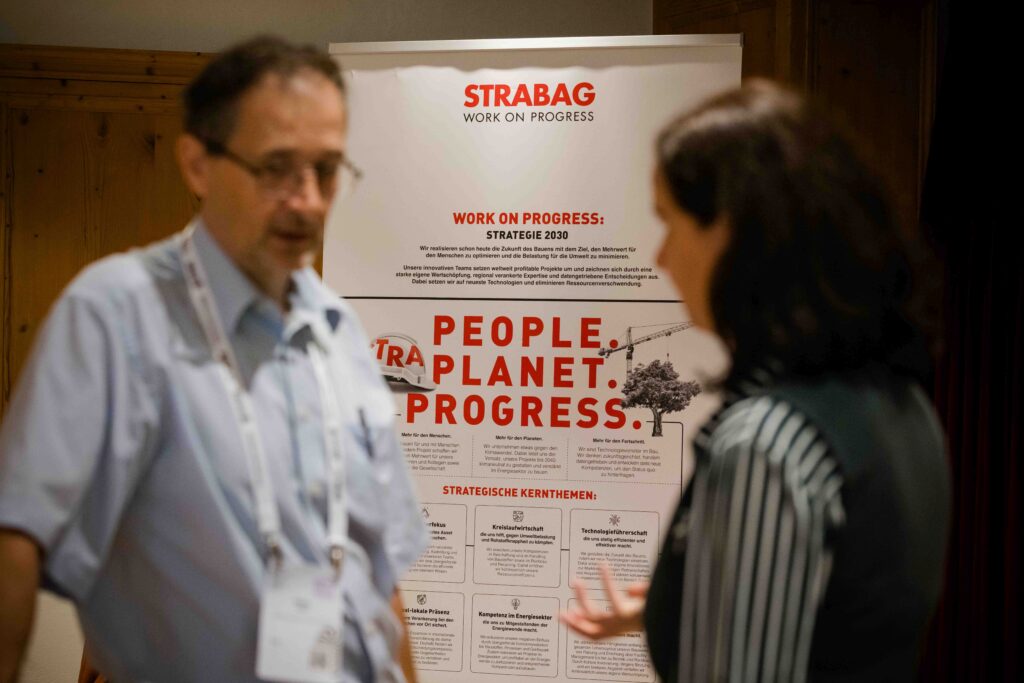 Zwei Personen unterhalten sich vor einem Flipchart